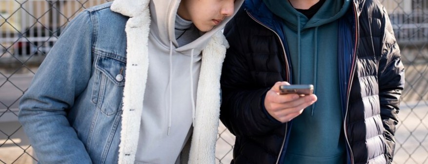 dos amigos adolescentes mirando el celular