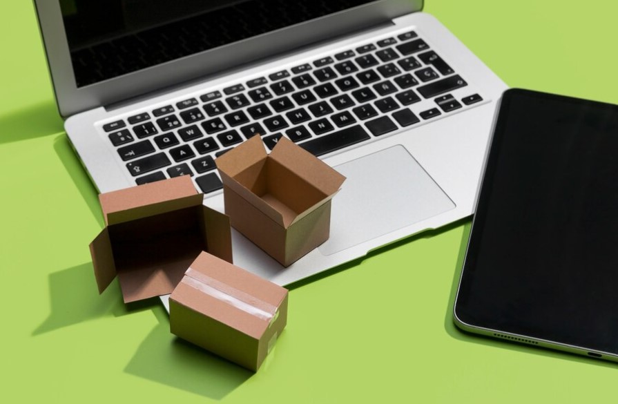 computadora y celular con cajas de e-commerce