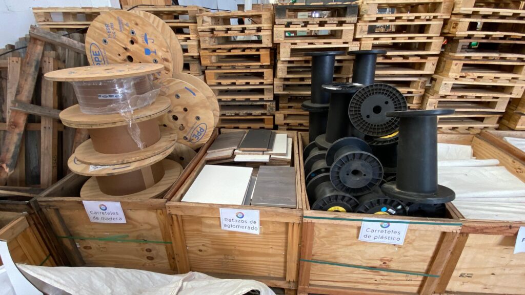 Imagen de cajones con carreteles de plástico, retazos de aglomerado y carreteles de madera.